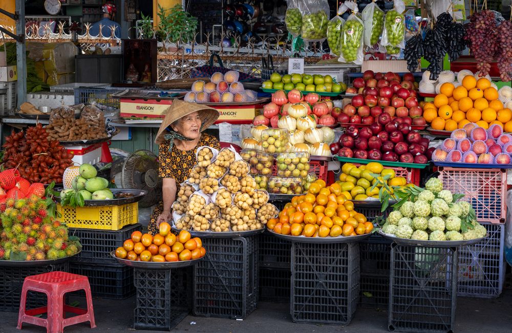 A Vietnamese woman by a fruit shop