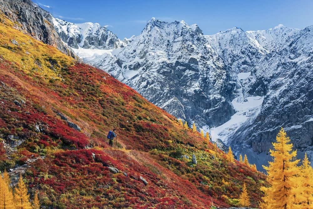 Красочные горные склоны на фоне заснеженных гор