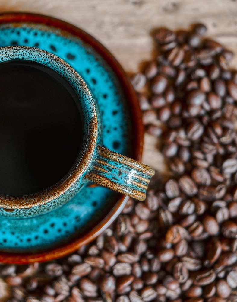 Blue cup of coffee and beans