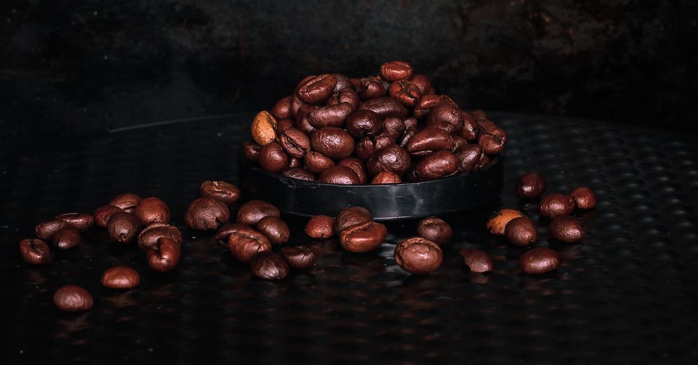 A small pile of roasted beans in an open, overflowing container