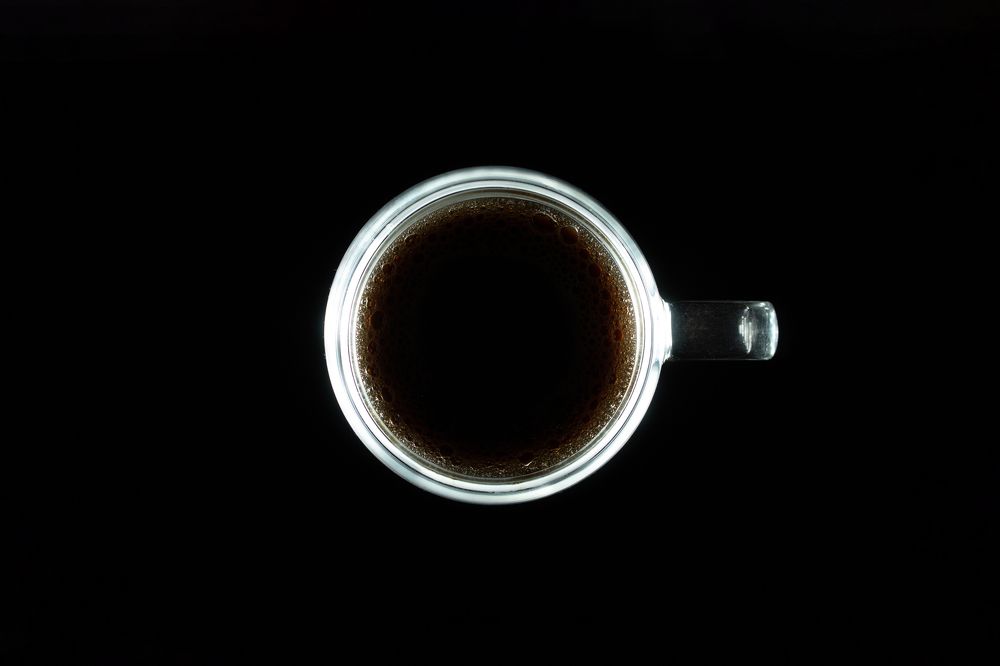 Black coffee in an illuminated cup.