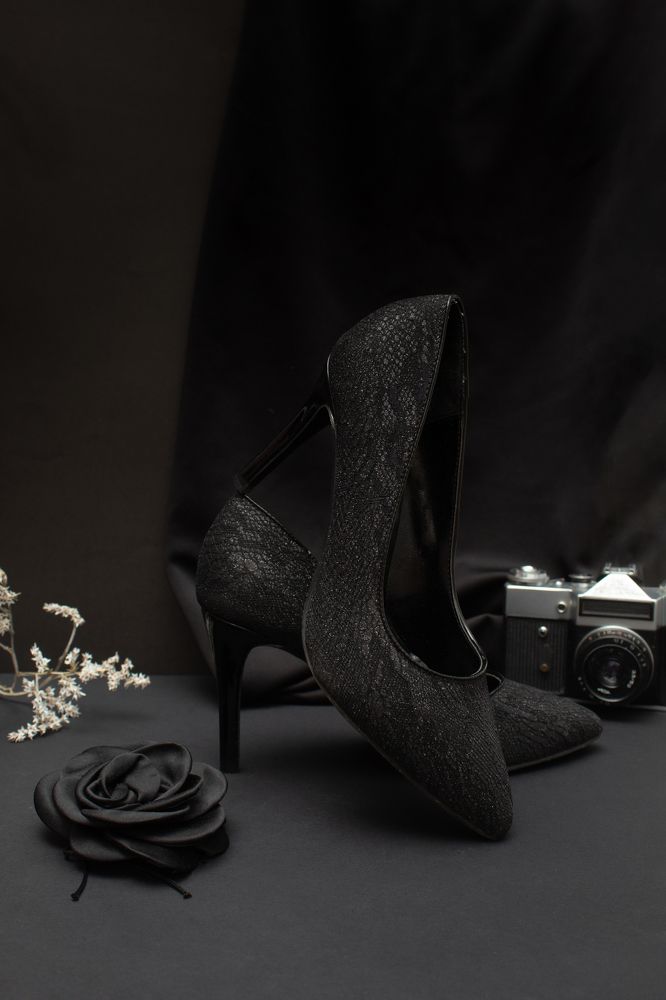 Black lace heel shoes with black background.