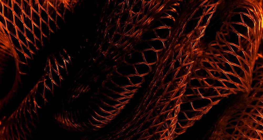 Part of a brown nylon washcloth close up in the intense darkness