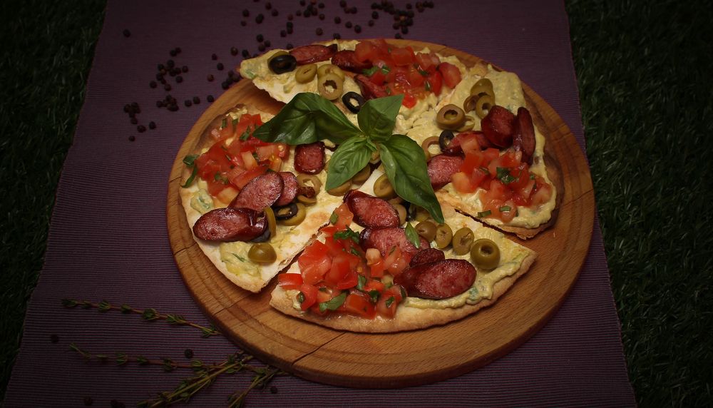 Lazy pizza with sausage divided into four parts