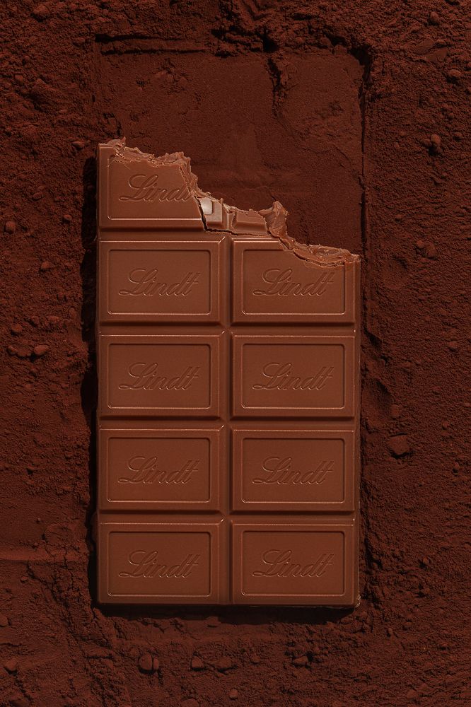 Bitten chocolate on cocoa dust.