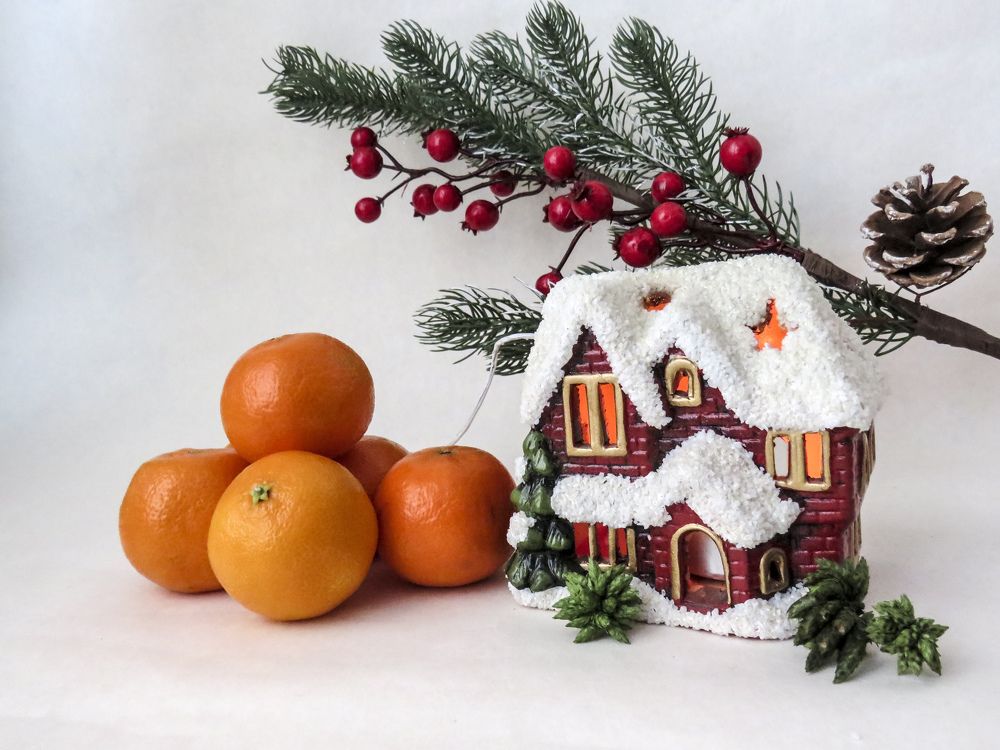 Tangerines and a miniature snow-covered house