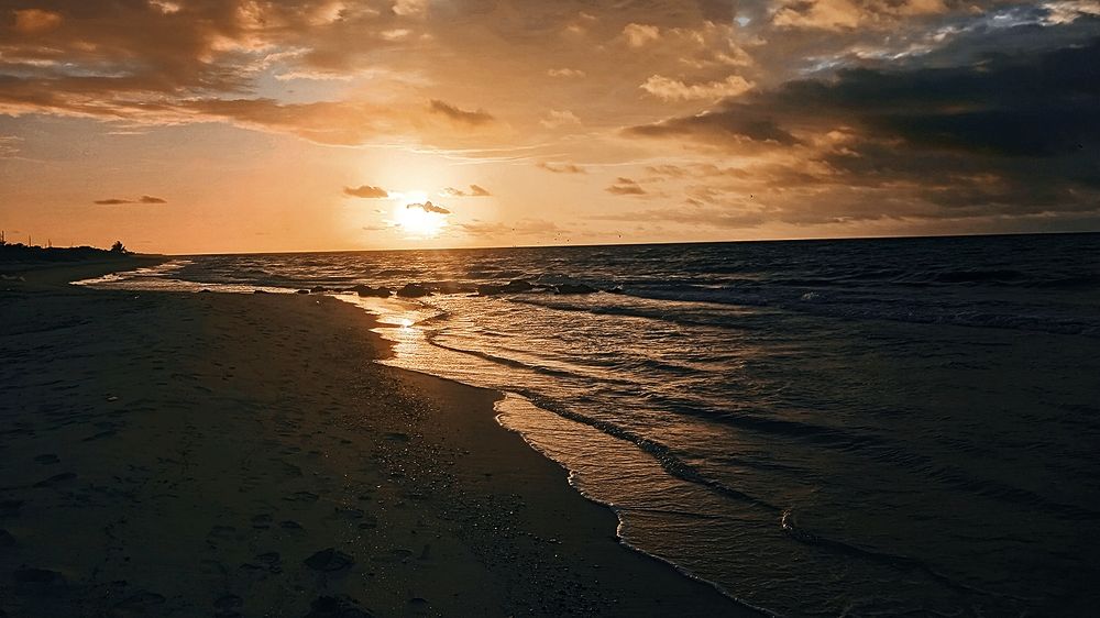 Últimos rayos del sol acariciando el horizonte costero