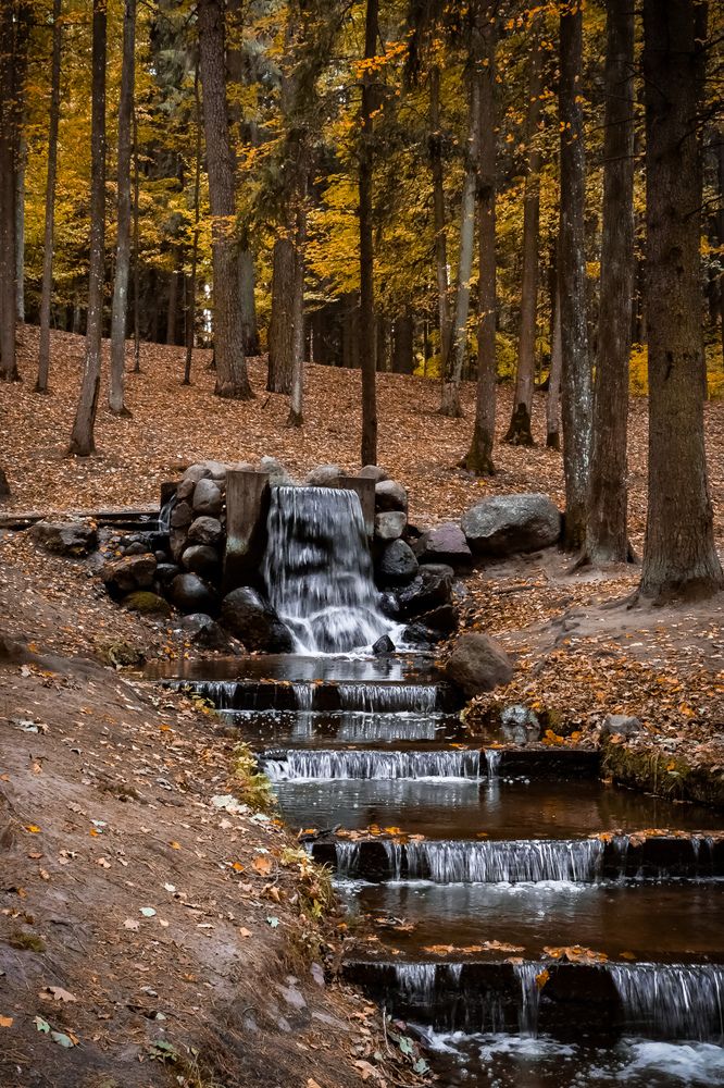 Водопад в осеннем городском парке.