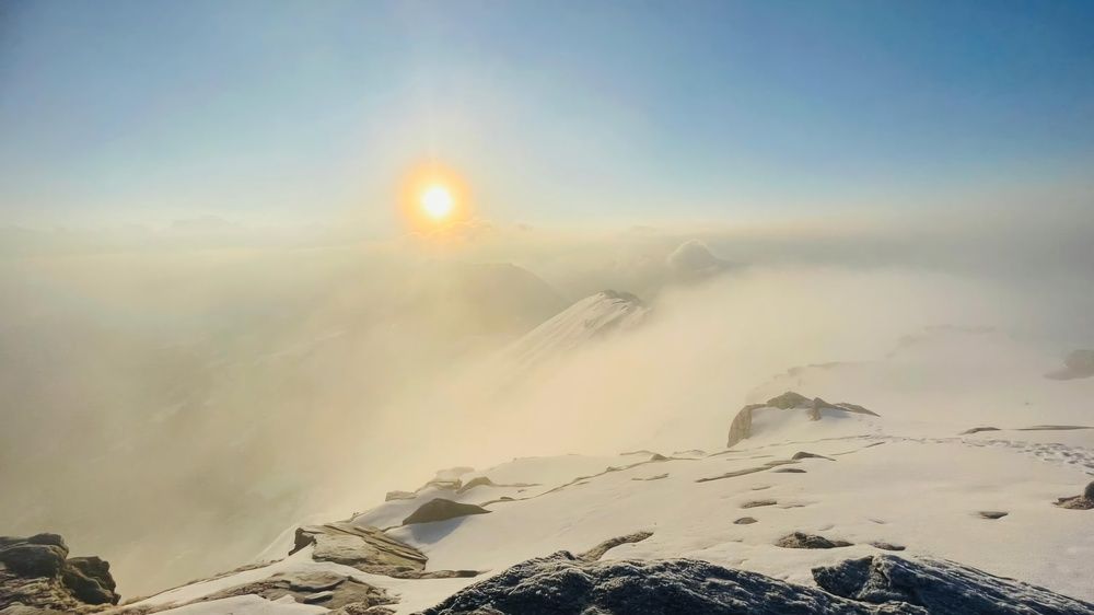 "Golden Sunrise Over a Snowy Mountain Peak"