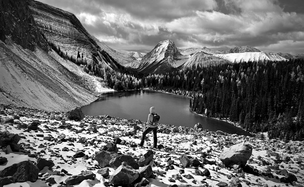 Hiker above the alpine lake in winter