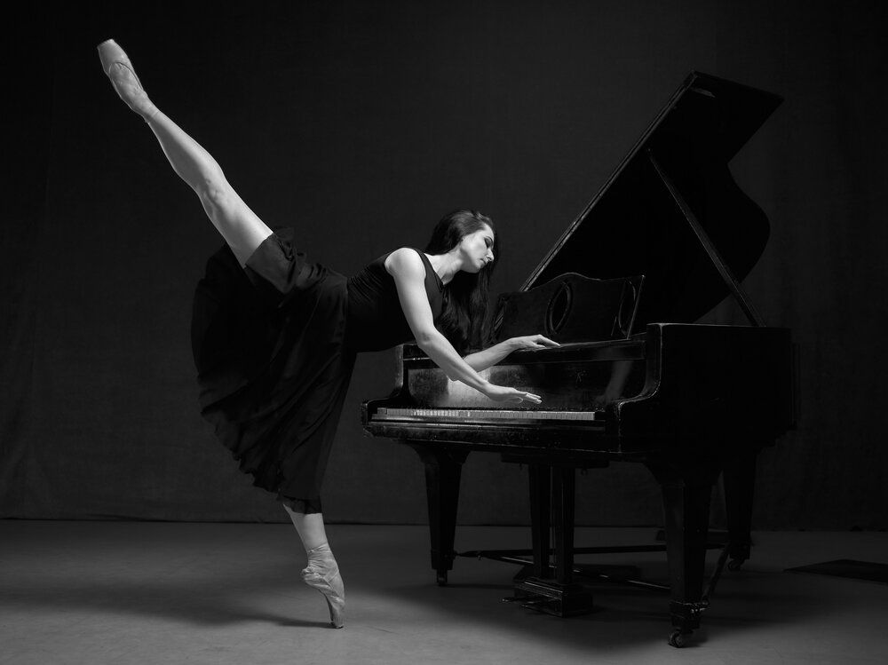 Black piano and white ballerina in a black dress