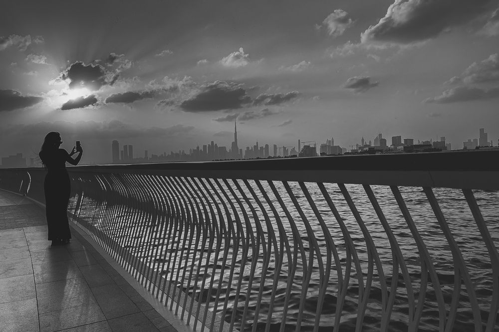 A lady clicking the Dubai Skyline at sunset