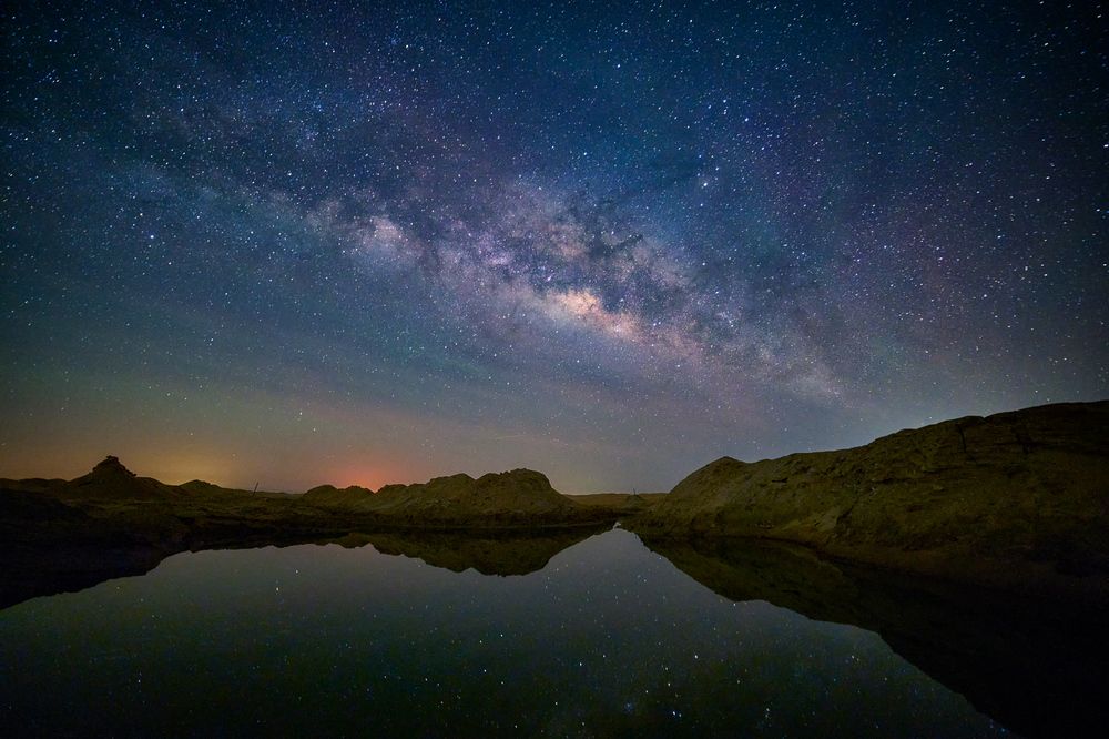 milky way with a small lake in the desert of abu dhabi