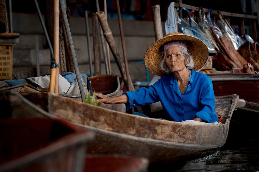 Old woman on woodenboat in Damnoen Saduak