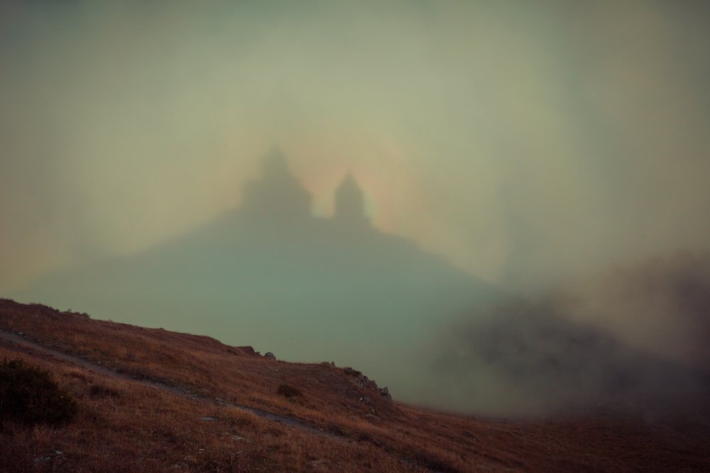 Радужный нимб над храмом Святой Троицы в Гергети. Грузия