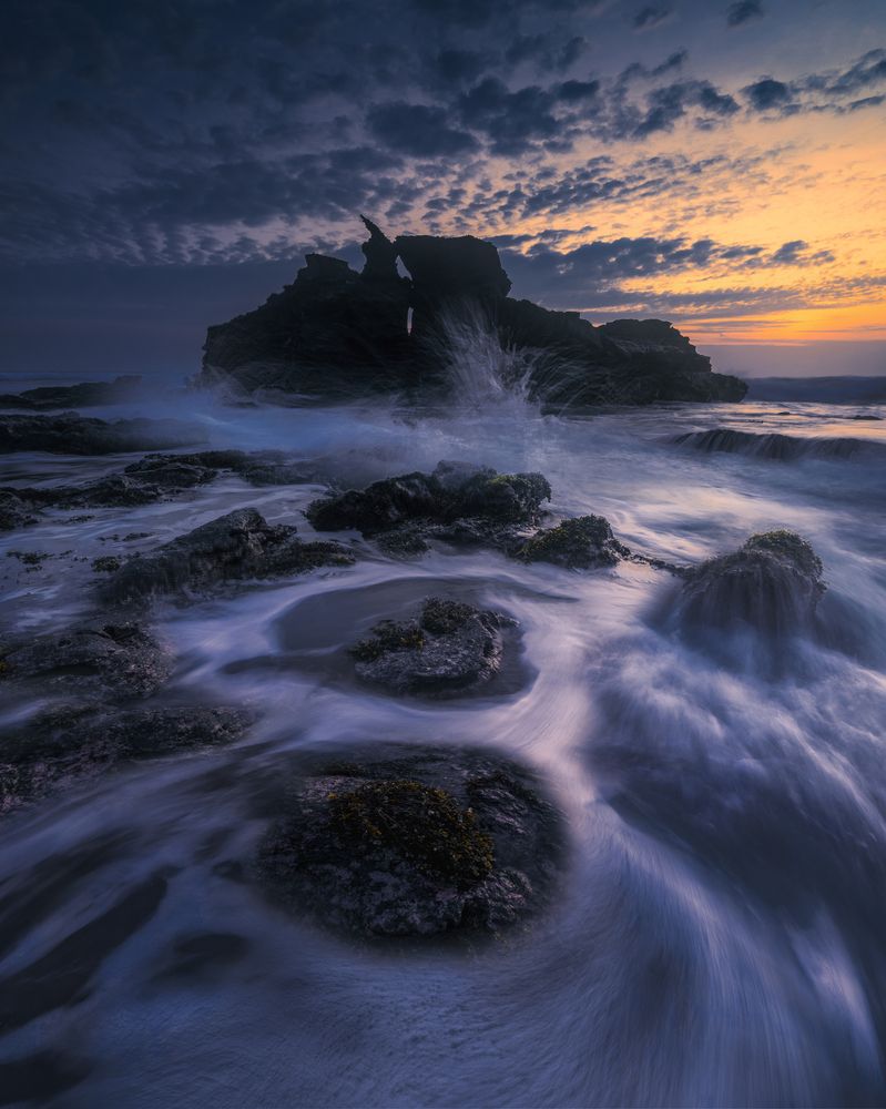 Silhouette of Rocks and Waves in Sunset Harmony