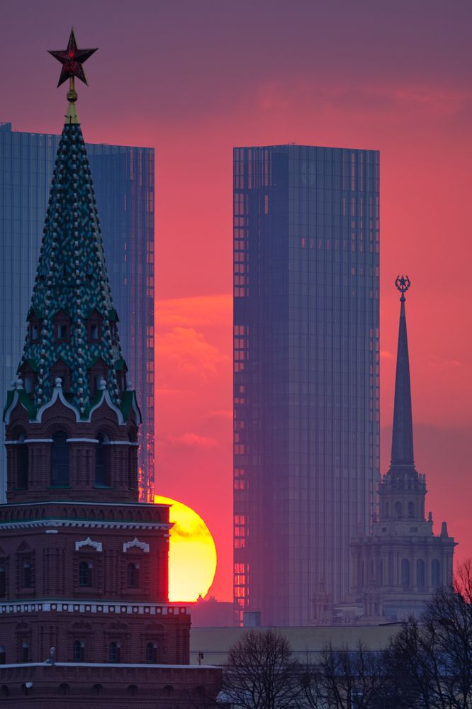 Москва. Боровицкая башня Кремля, небоскрёбы Кэпитал Тауэрс, высотка гостиницы Украины и заходящее солнце.