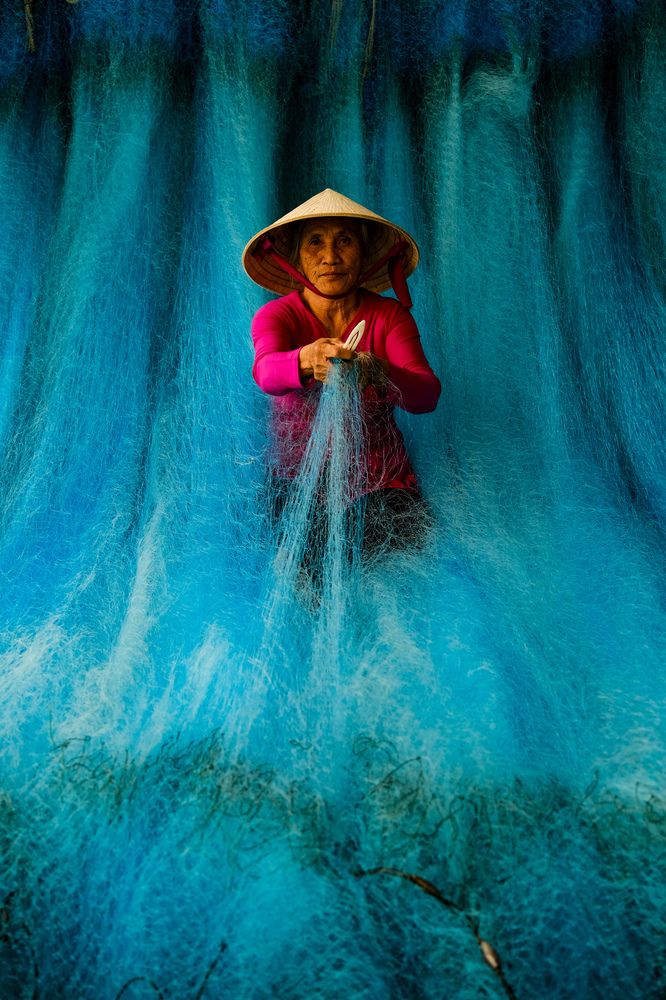 Donna che ripara reti da pesca