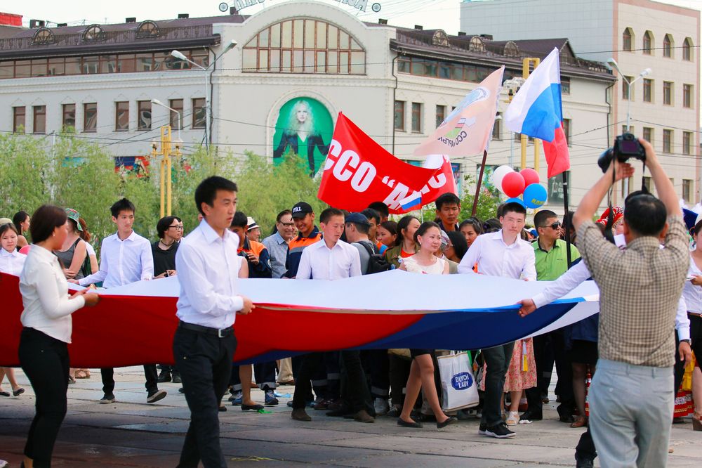 Студенты несут флаг России.