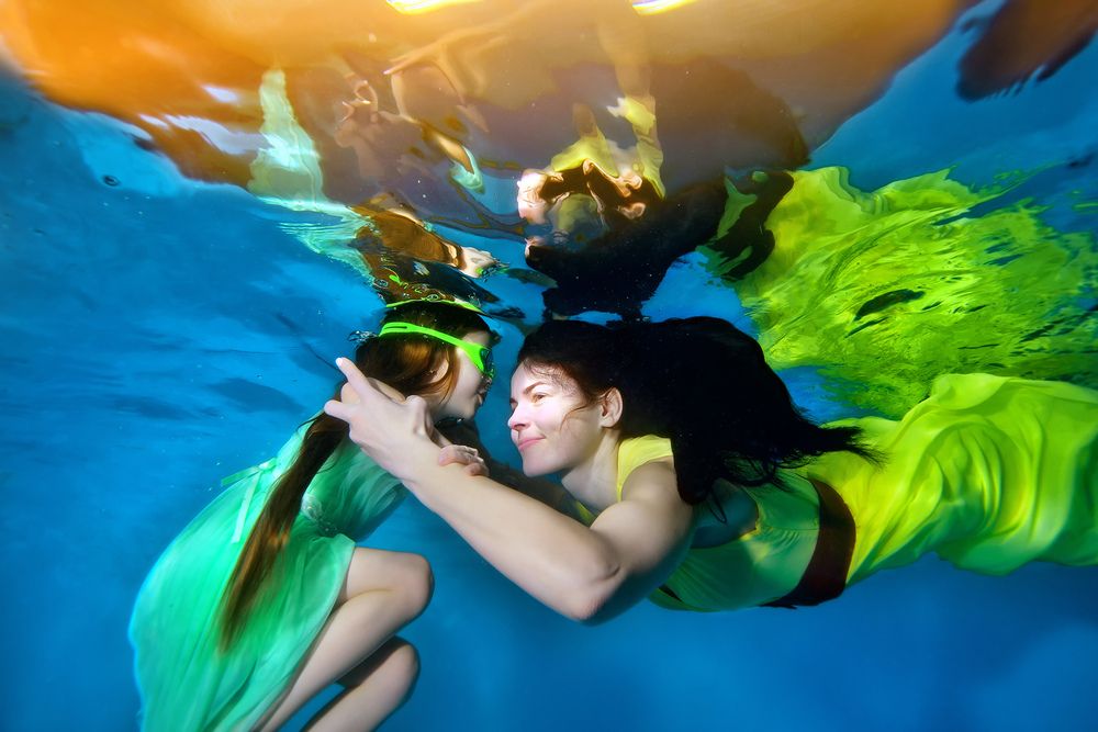 Семья русалок под водой.