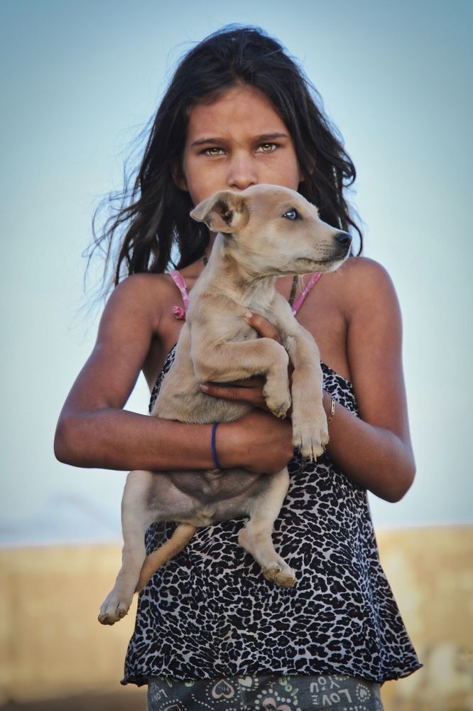 Niña y su cachorro en un pueblito de Macanao