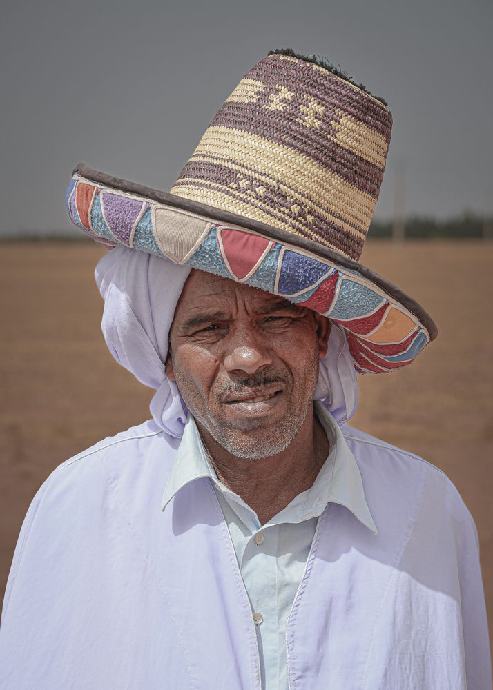 The authentic desert man with his traditional colorful face and hat details