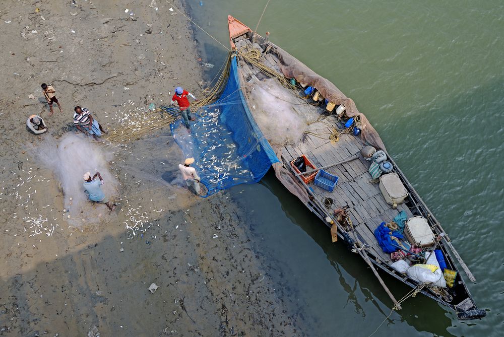 FISHERMEN BY THE BOAT