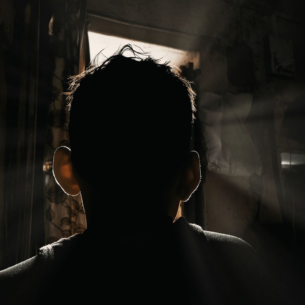 Backlit Silhouette of a Pensive Person by the door