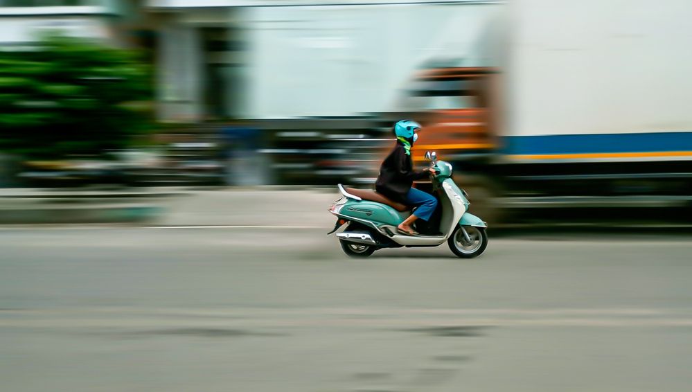 Panning shot of a woman on a scooter