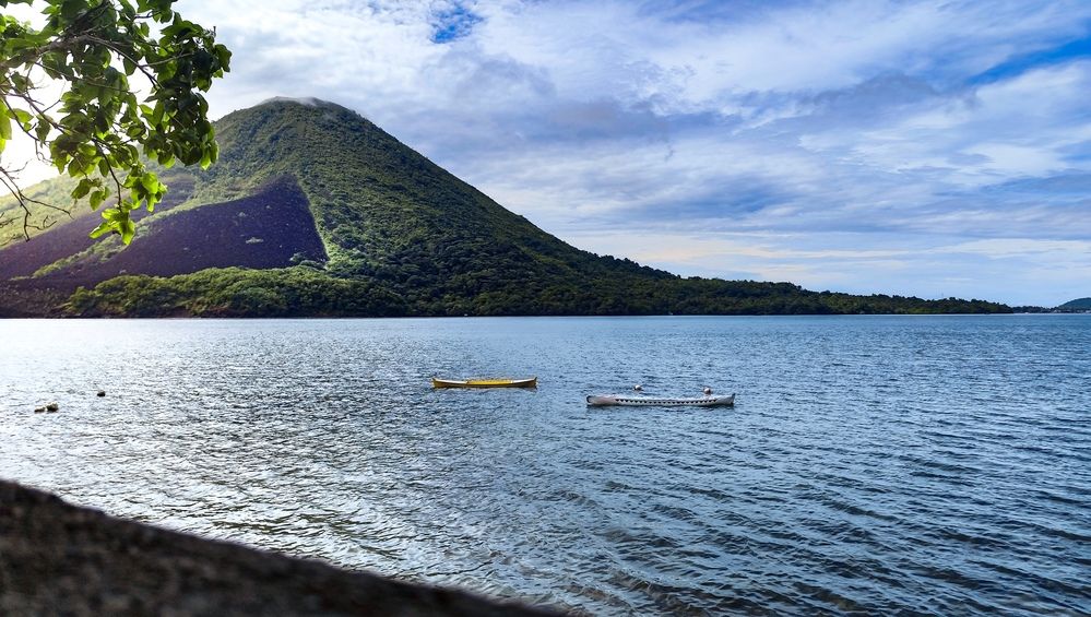 Scenic Volcano and Calm Sea with Traditional Boats