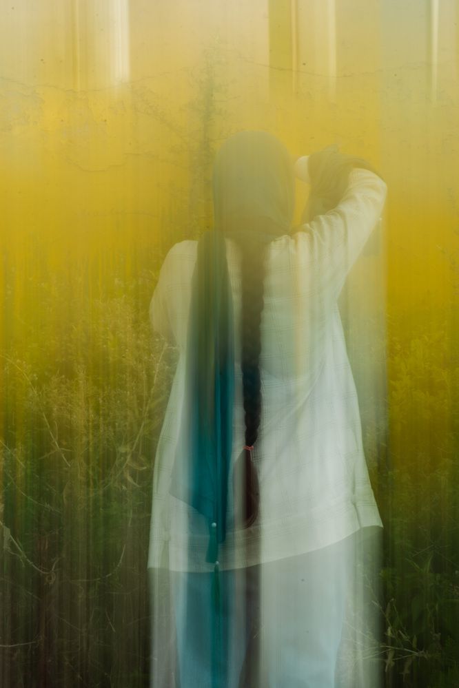 A girl amidst a dream of green and yellow colors