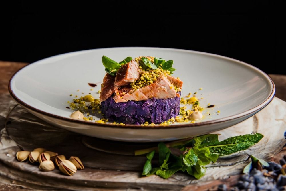 Red tuna on purple potato flatbread and chopped pistachios.