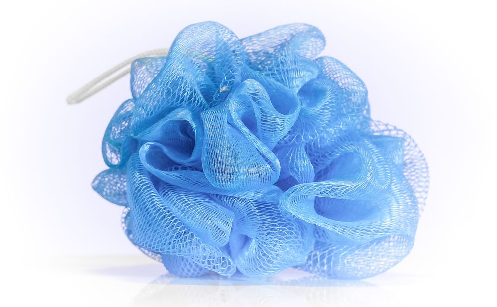Blue nylon washcloth in bright light on white background