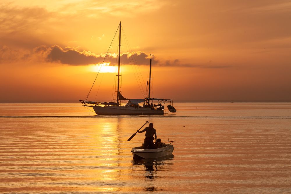 Fisherman beside SailBoat