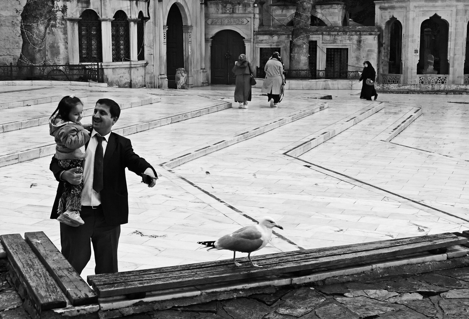 Father holding child in a historic courtyard