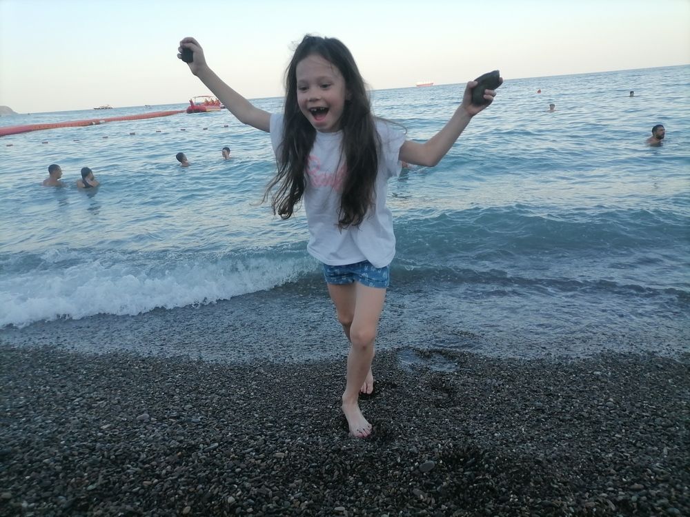 Радостная девочка бегущая из моря.