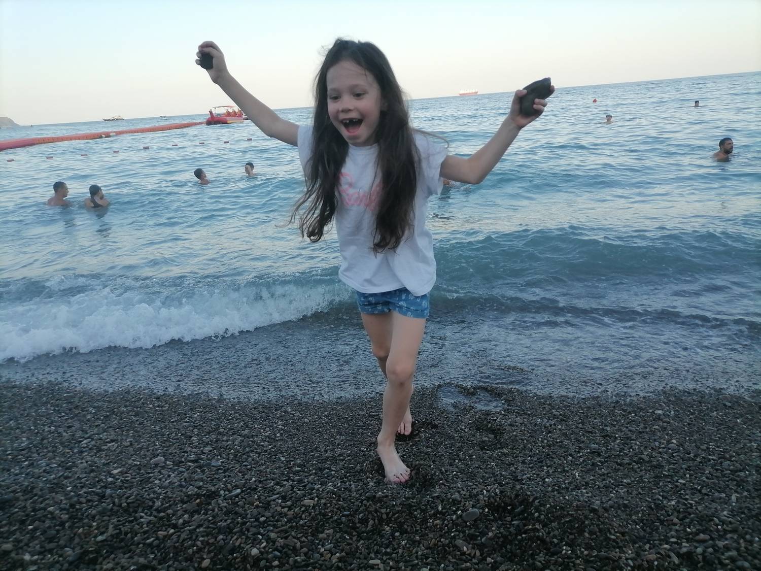 Радостная девочка бегущая из моря.