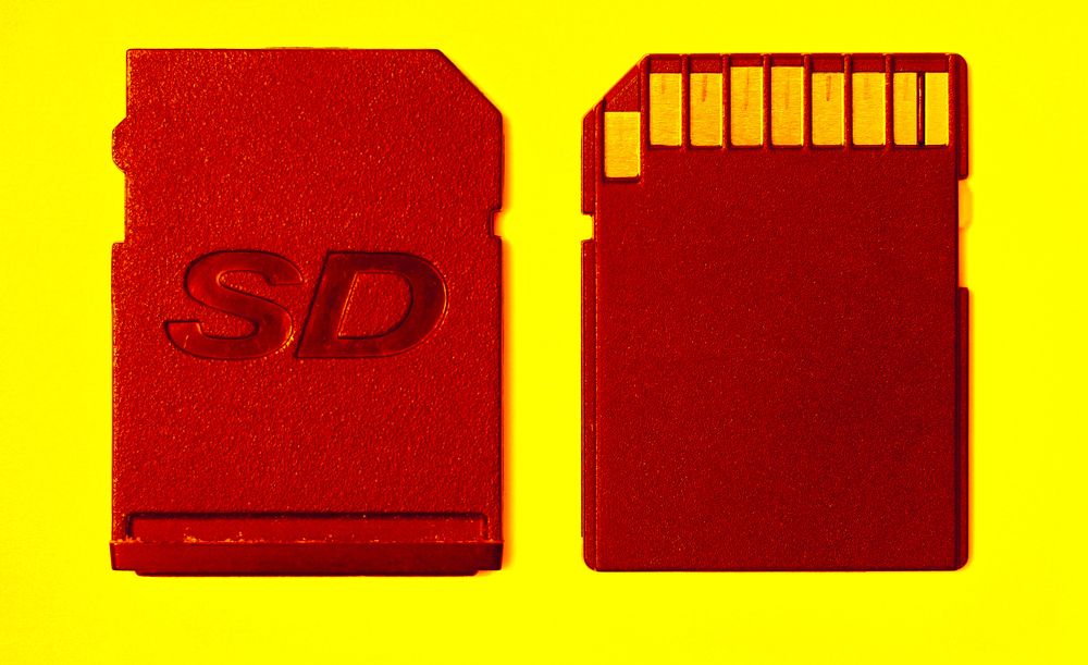Red memory card and slot cover on a yellow background
