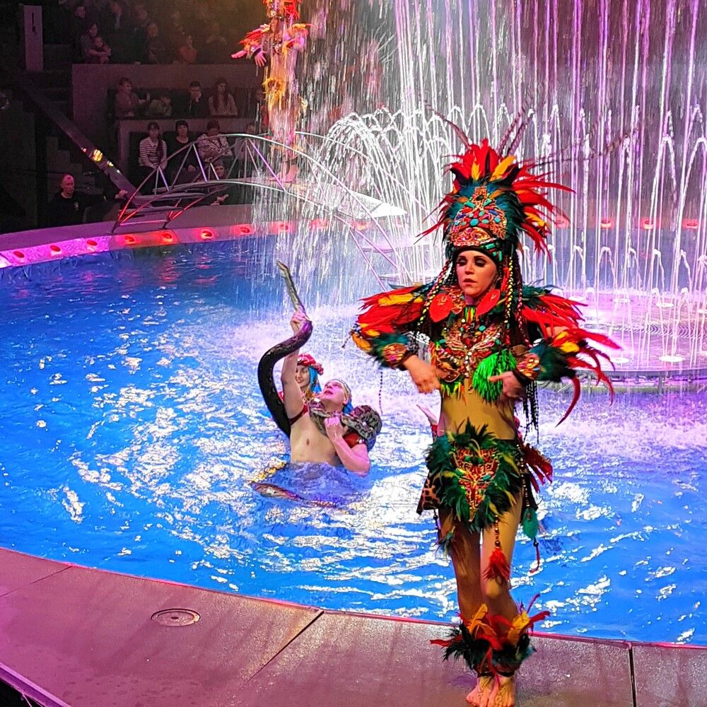 Артистка в ярком костюме, украшенном перьями и орнаментами, характерными для экзотических образов