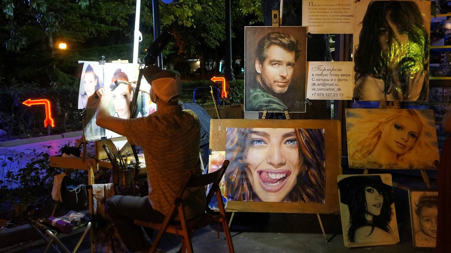 Уличный художник, работающий над портретом