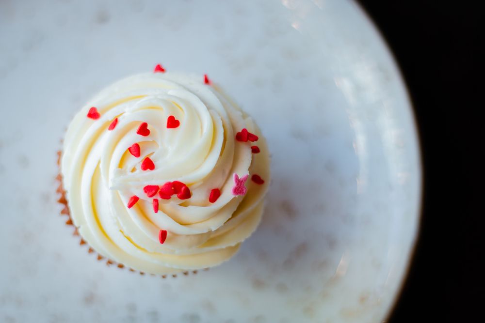 cupcake with buttercream frosting and heart-shaped sprinkles