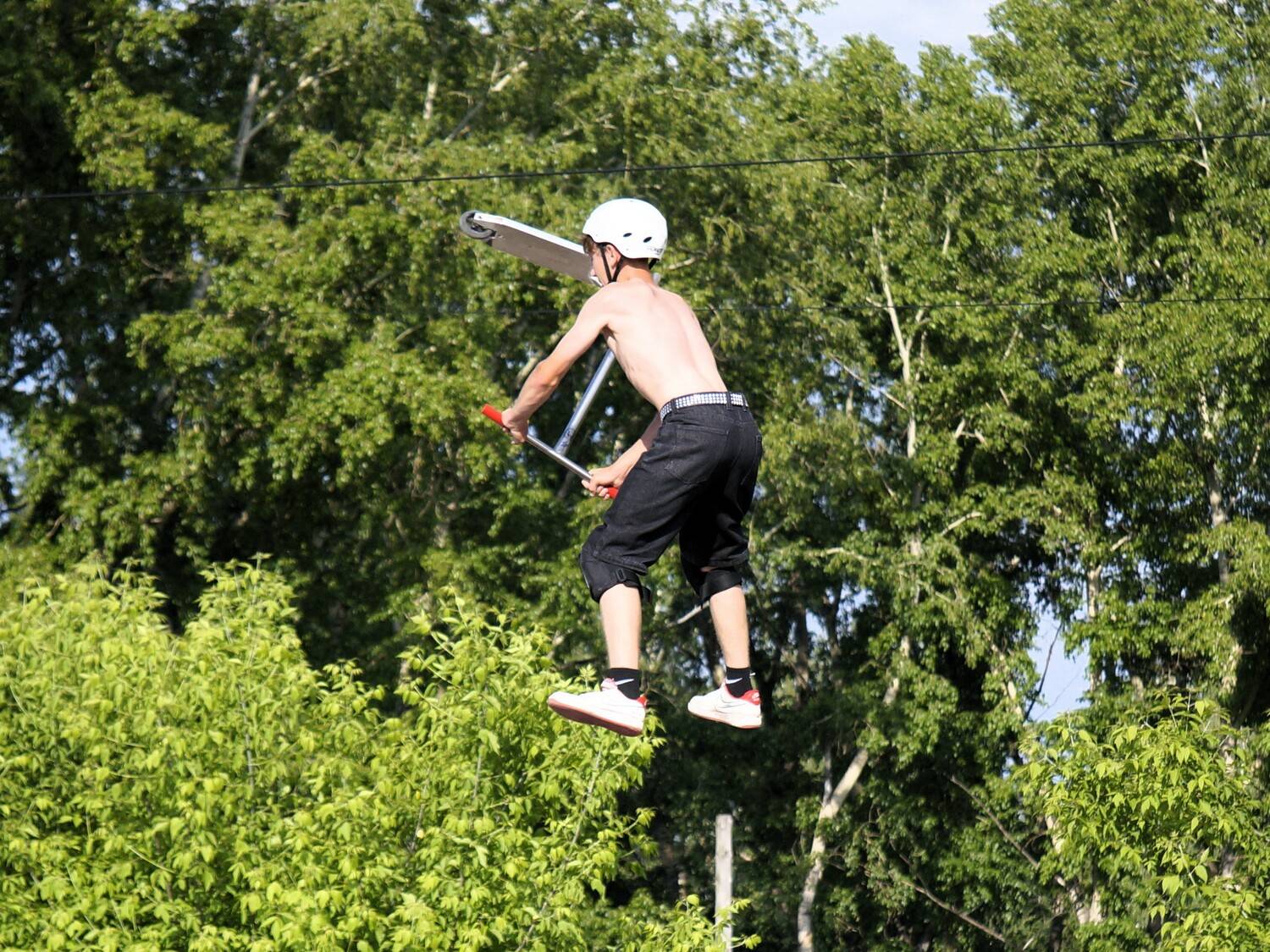Динамичный момент исполнения экстремального трюка на самокате в воздухе