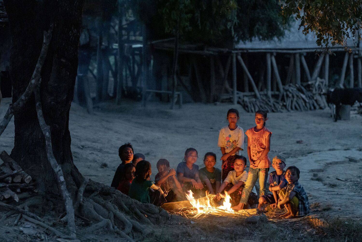 Mro children of the Chittagong Hill Tracts gather around a campfire, sharing stories and finding light in the embrace of the night.