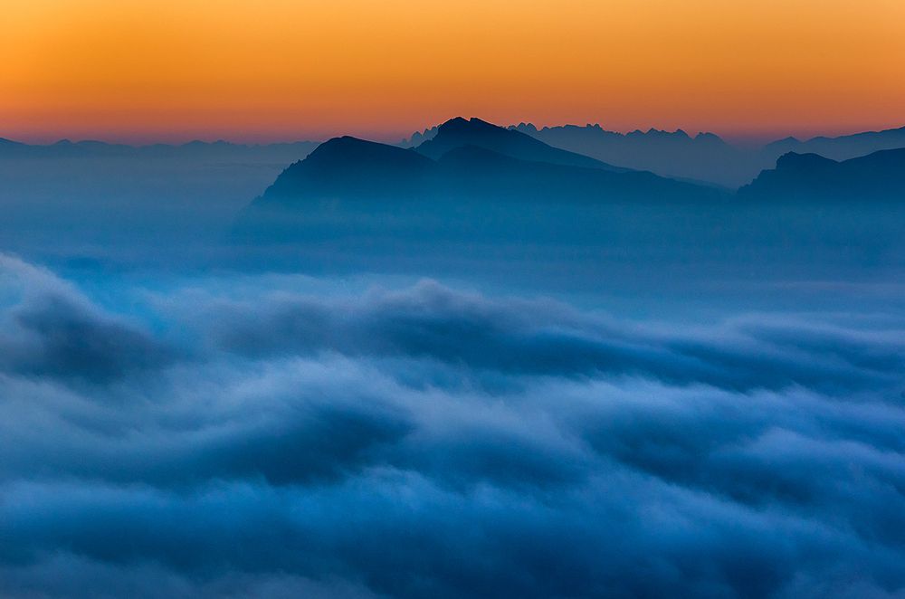 Clouds and lights over Dolomites before dawn