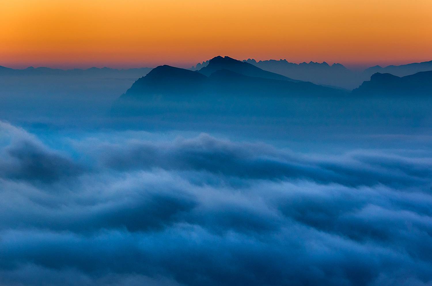 Clouds and lights over Dolomites before dawn