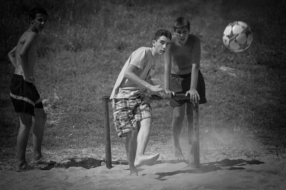 Youth Playing Soccer on a Sandy Field