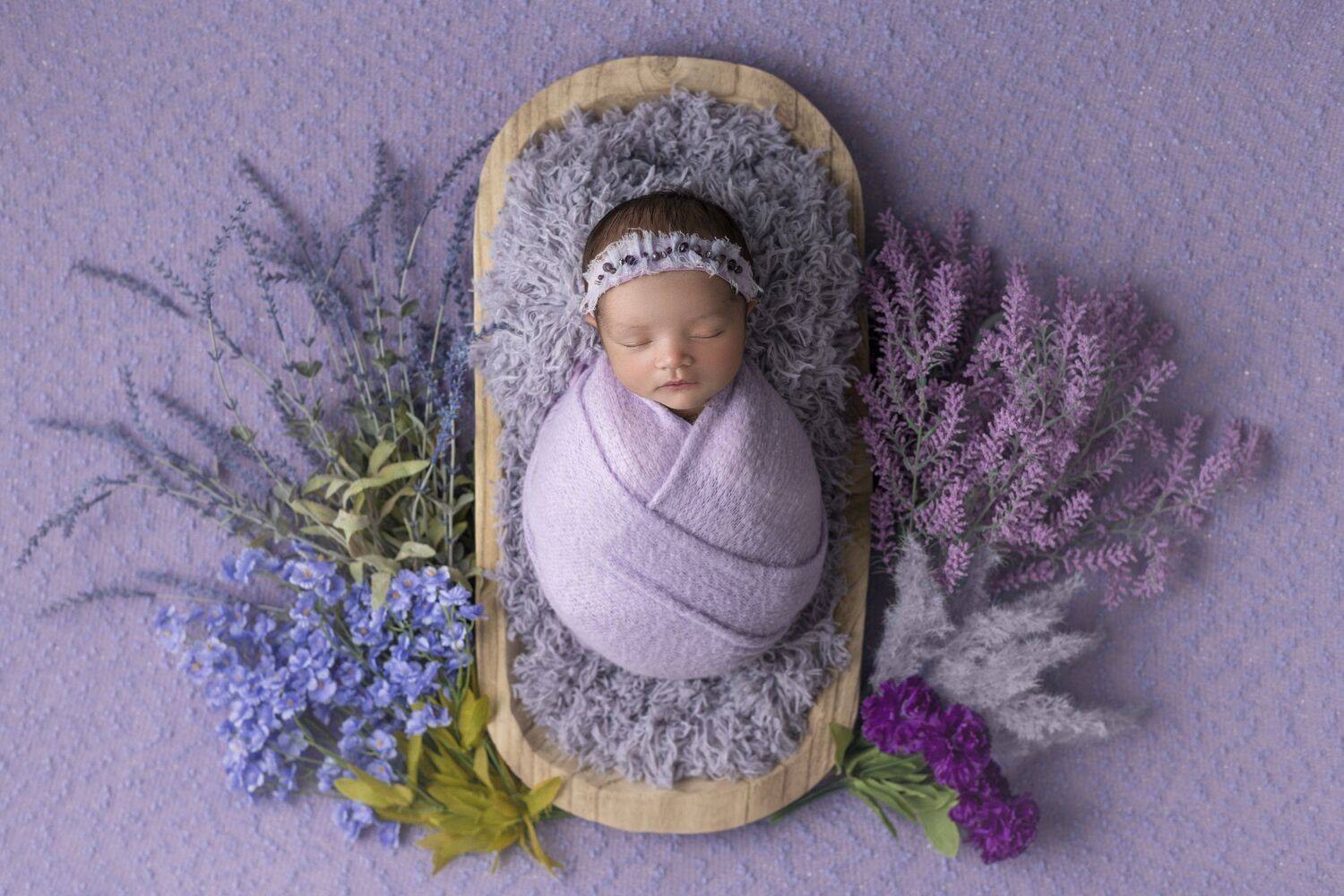 Newborn girl with purple flowers