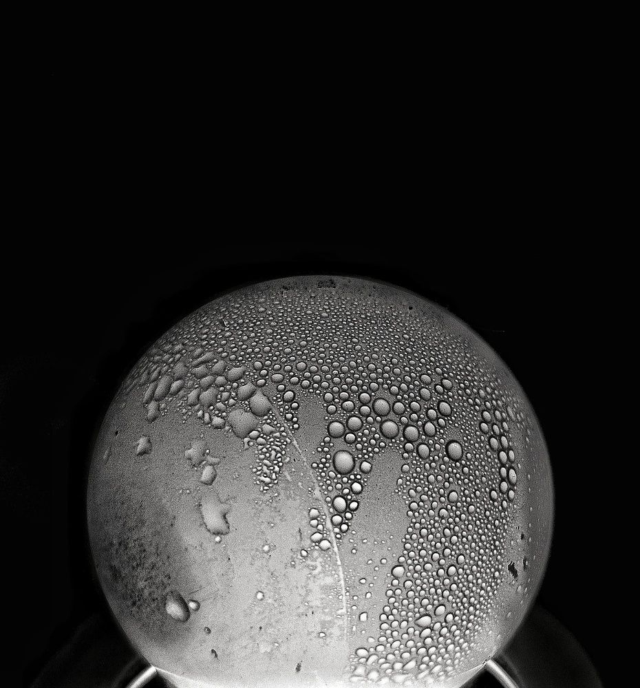 Light Bulb Covered in Condensation Droplets Black Background