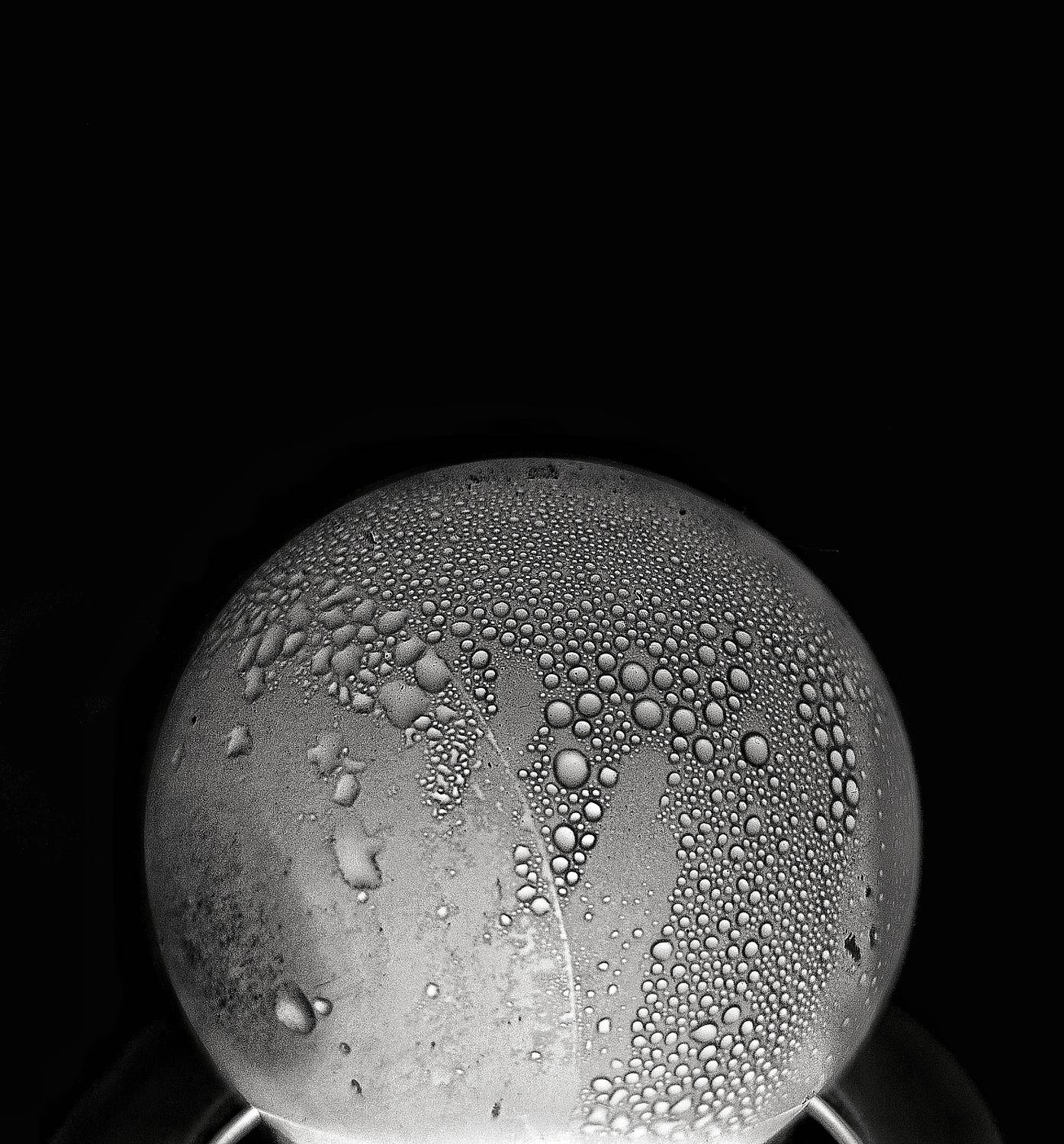 Light Bulb Covered in Condensation Droplets Black Background