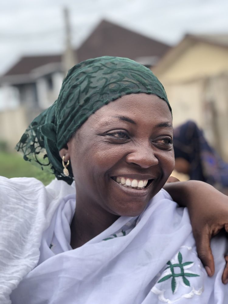 Smiling Woman in Traditional White and Green Headscarf